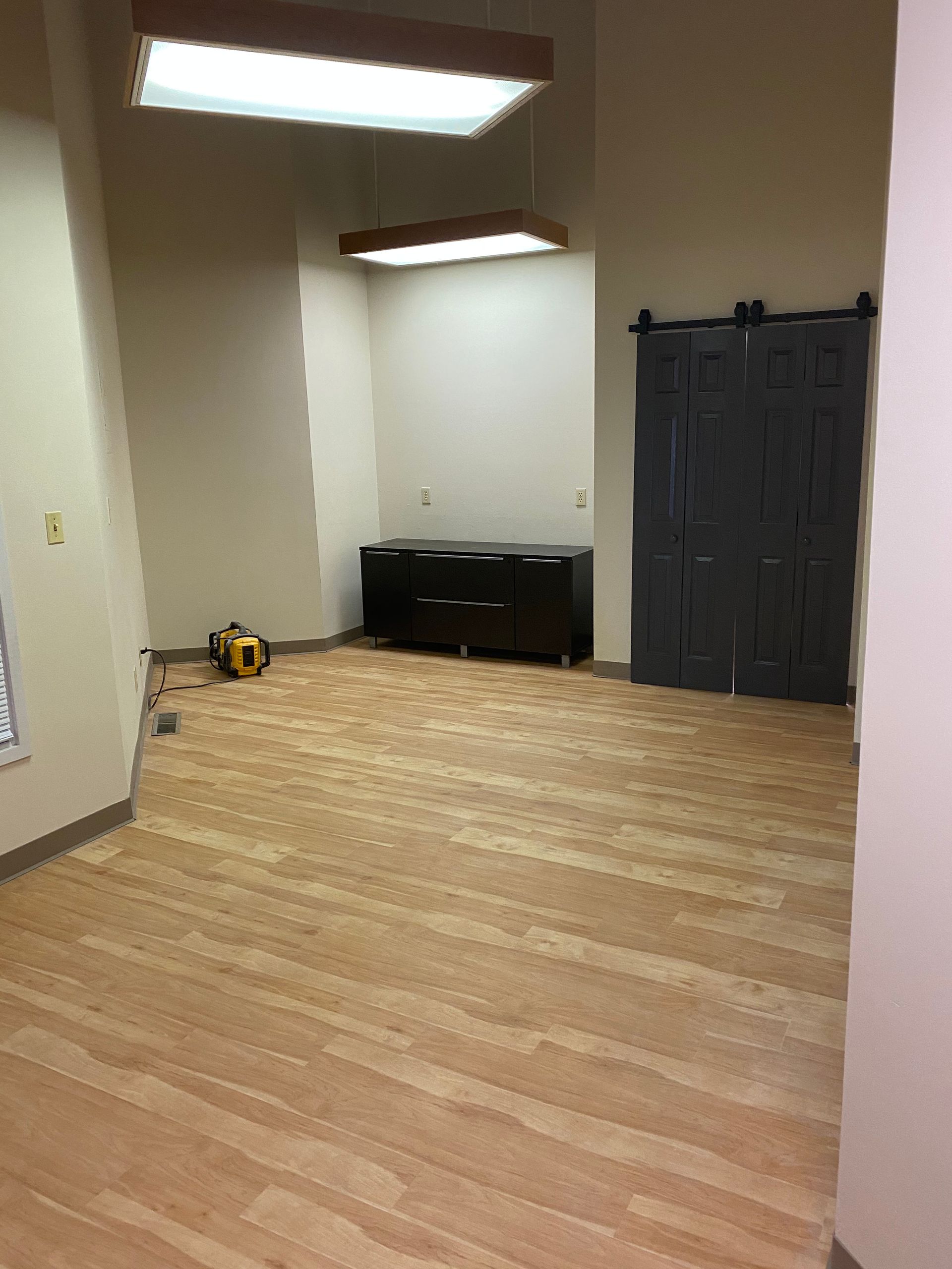 An empty room with wooden floors and a sliding barn door.