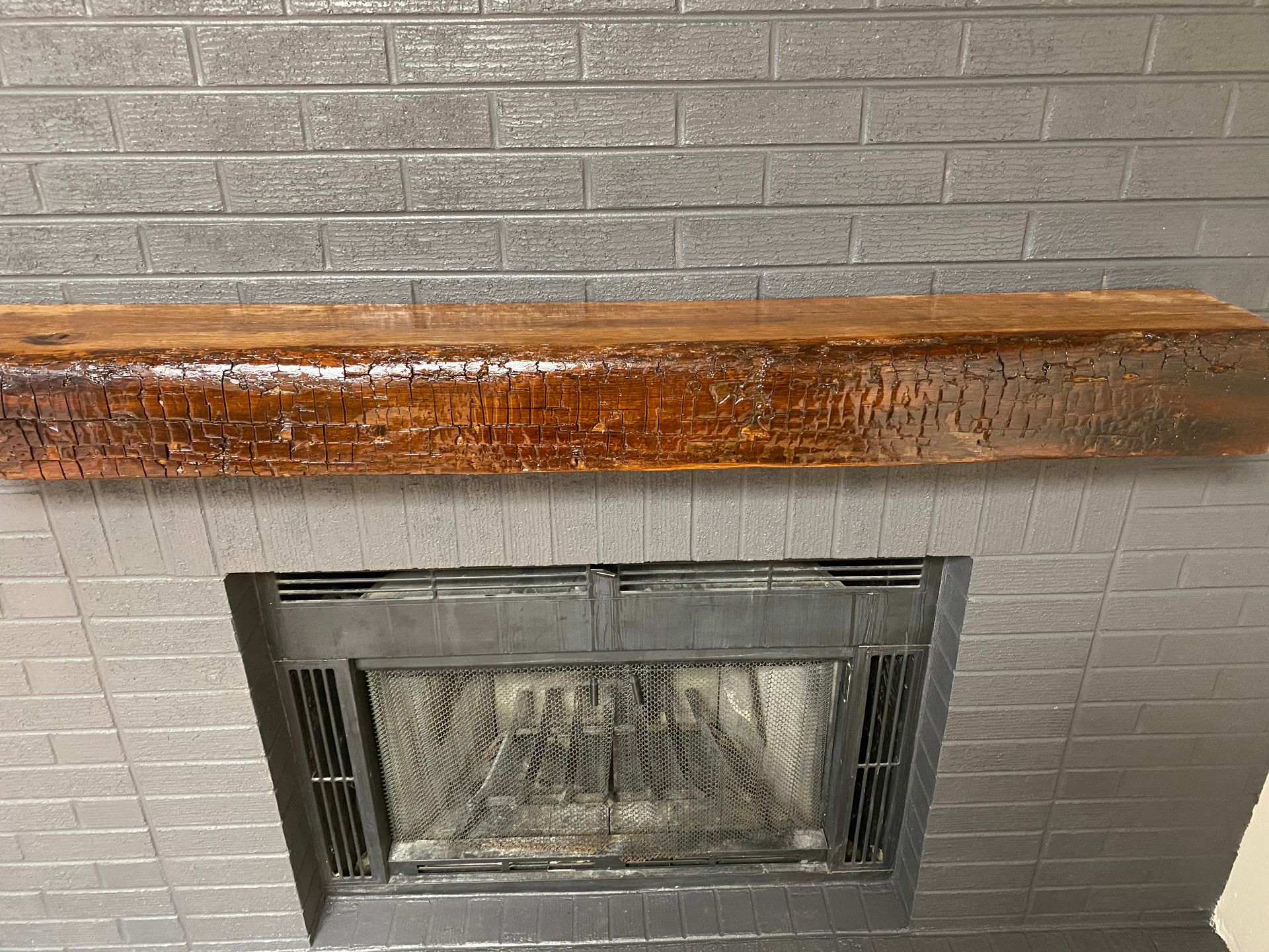 A fireplace with a wooden mantle above it.