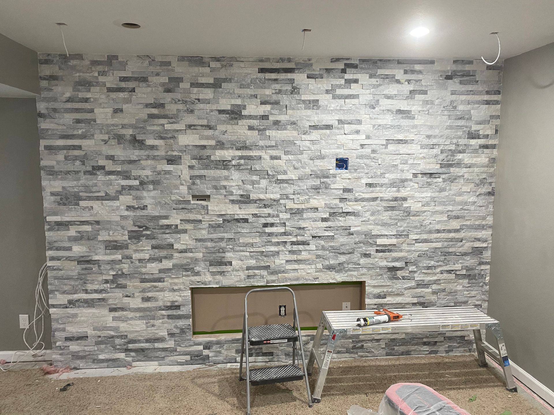A room with a stone wall and a fireplace in it.