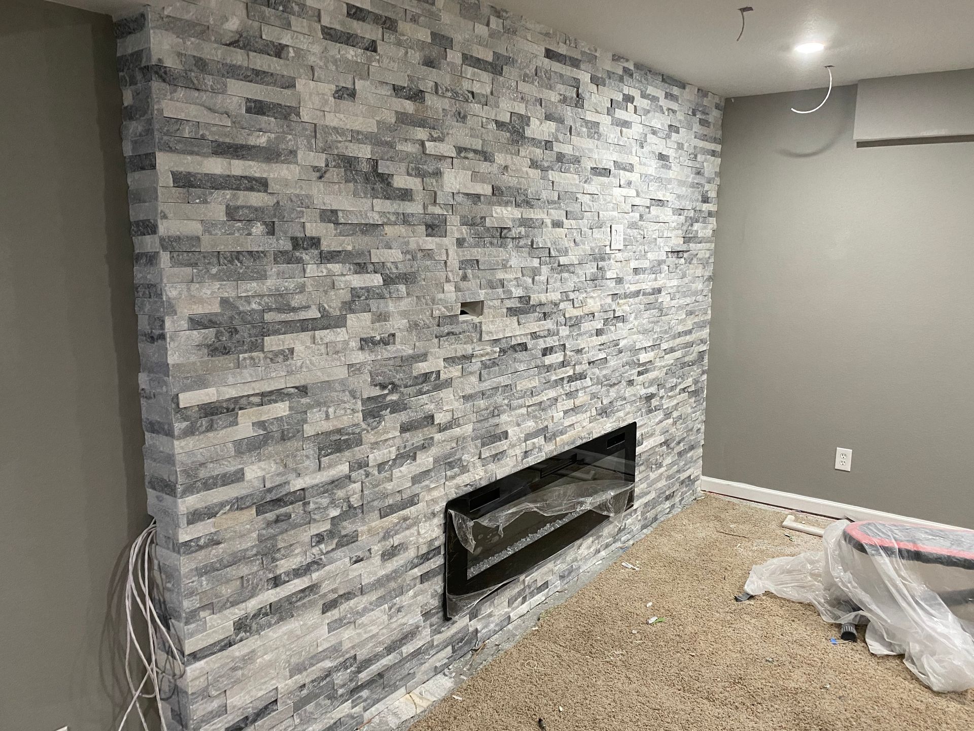 A living room with a fireplace and a brick wall.