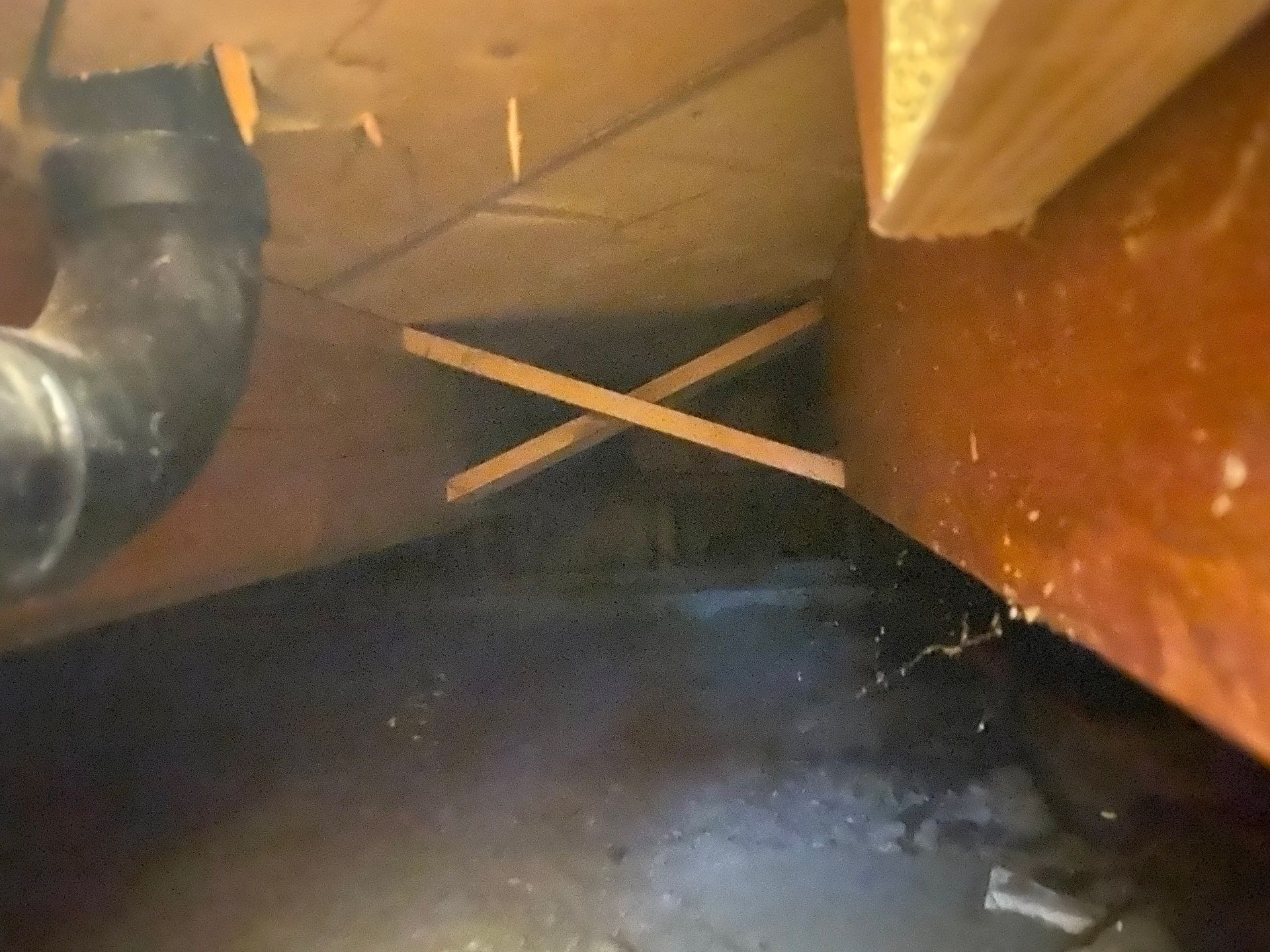 A close up of a pipe under a wooden ceiling.