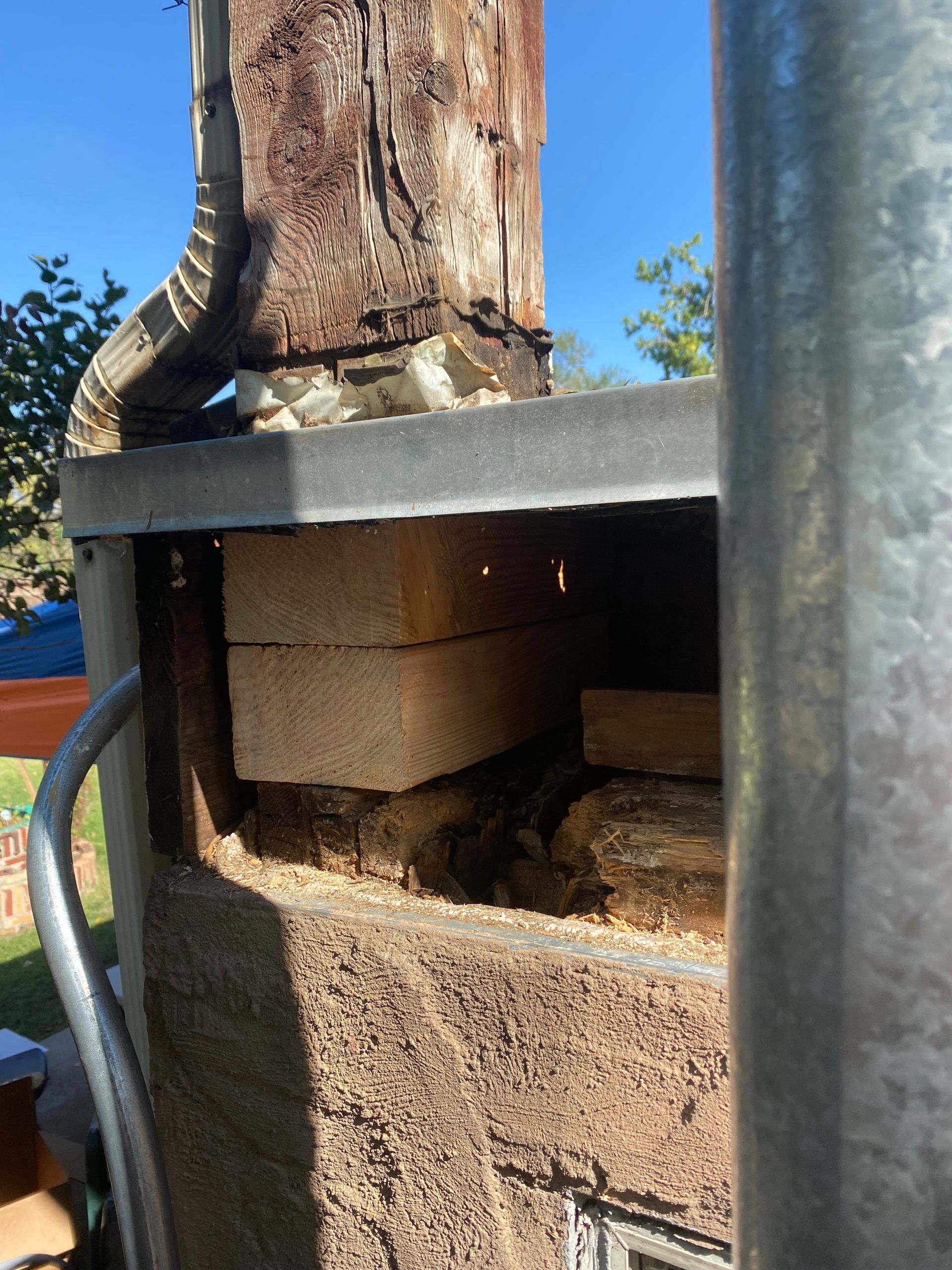 A close up of a brick wall next to a metal pole.