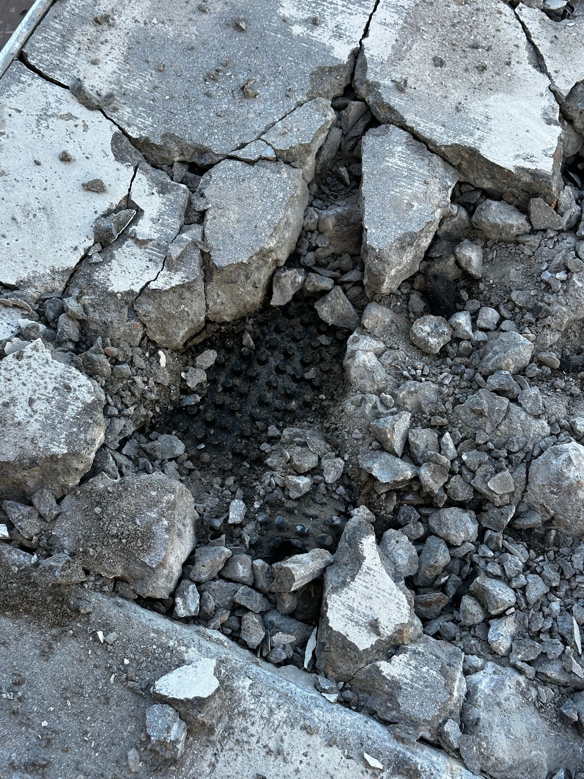 A pile of rocks and concrete with a hole in the middle.
