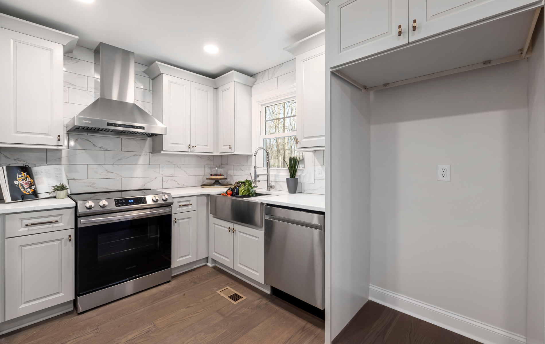 A kitchen with white cabinets , stainless steel appliances , and a sink.