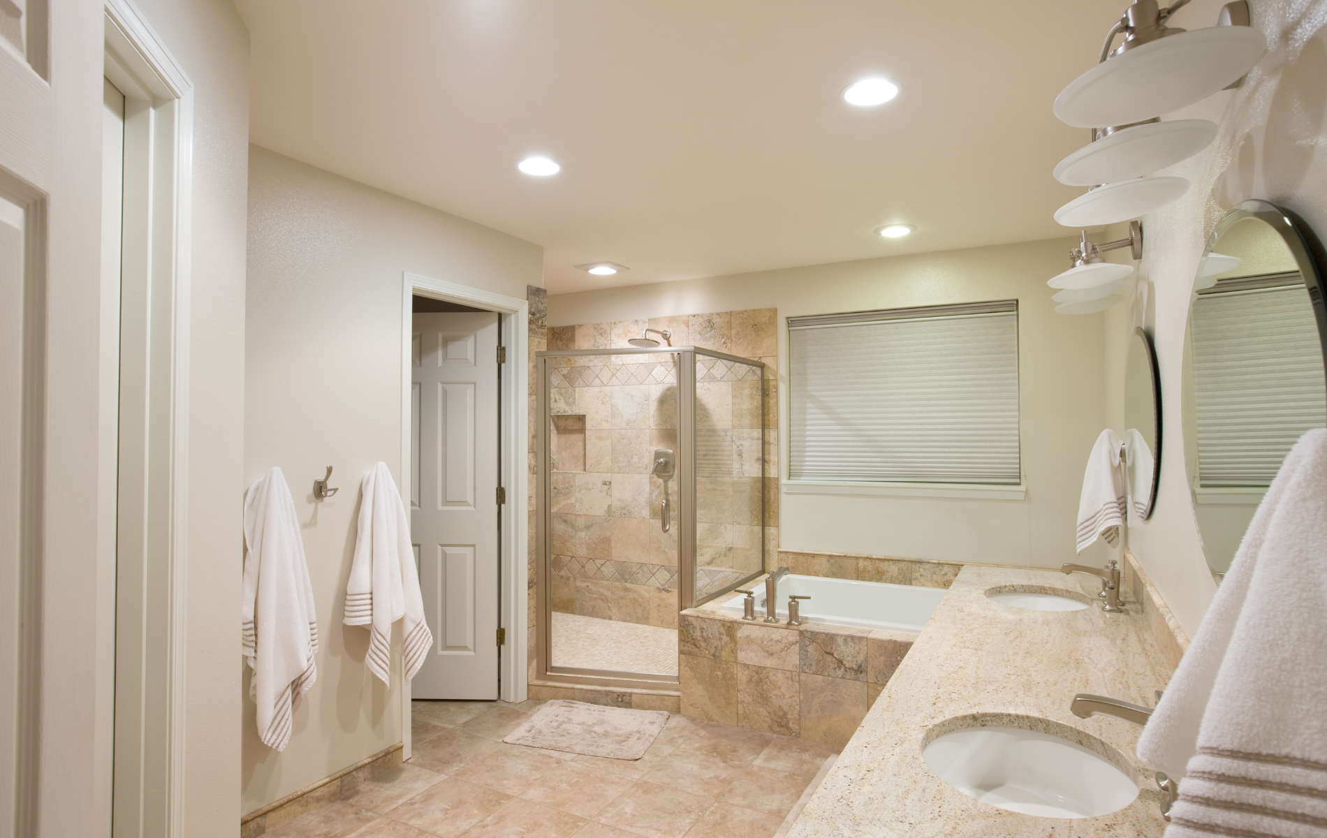 A bathroom with two sinks , a tub , and a walk in shower.
