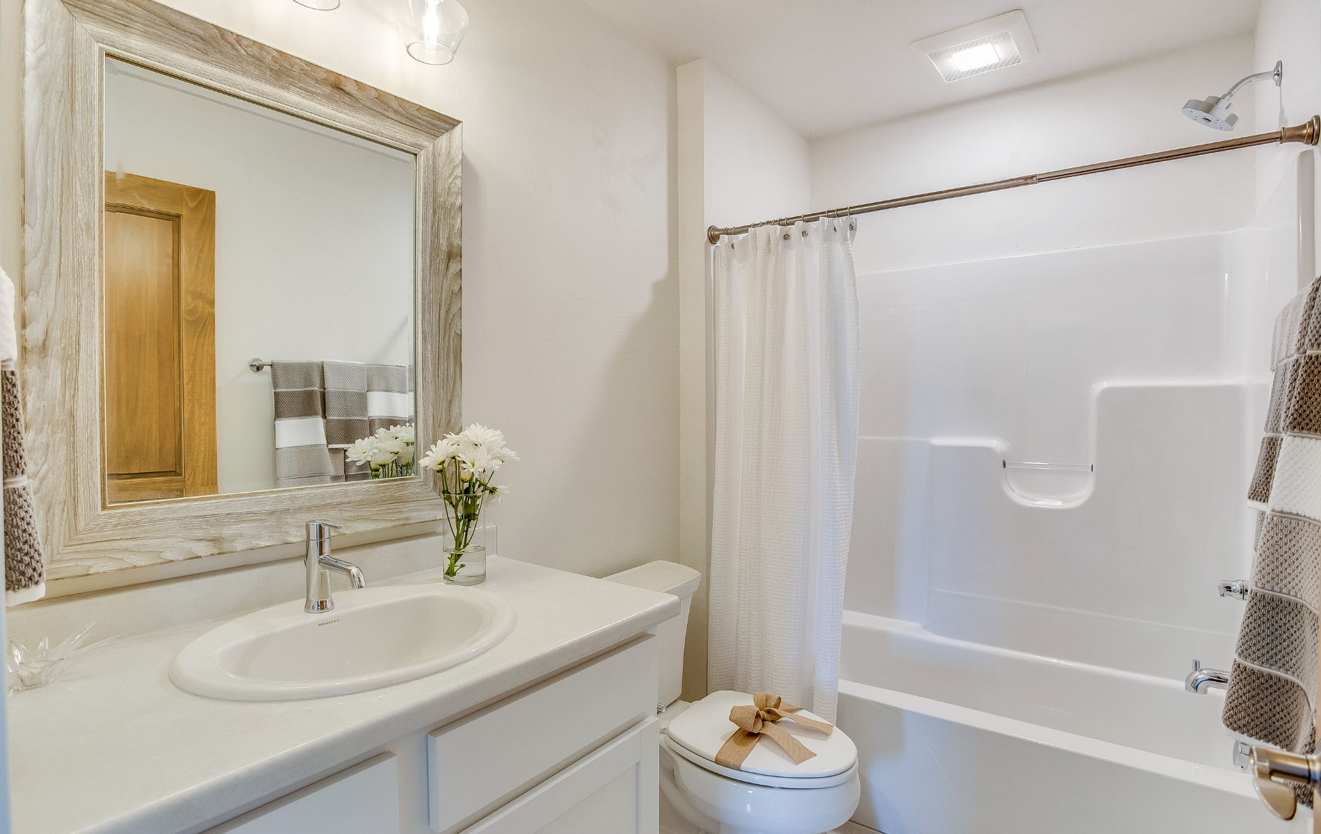 A bathroom with a sink , toilet , bathtub and mirror.