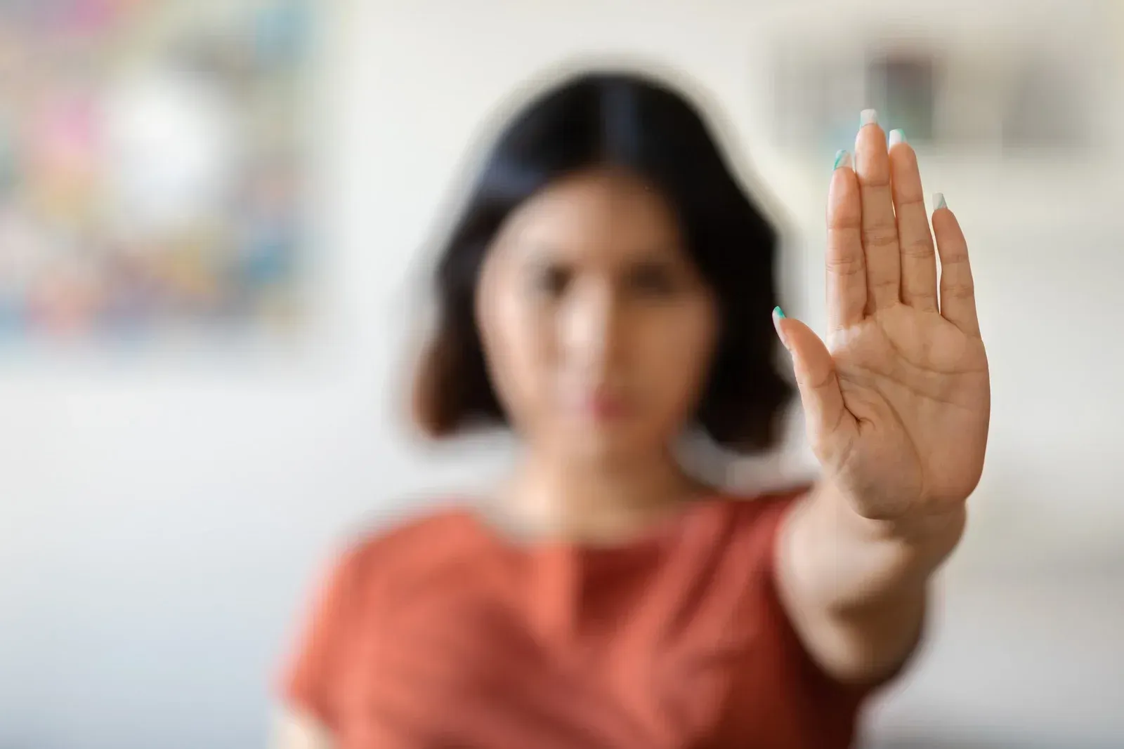 A woman is making a stop sign with her hand.