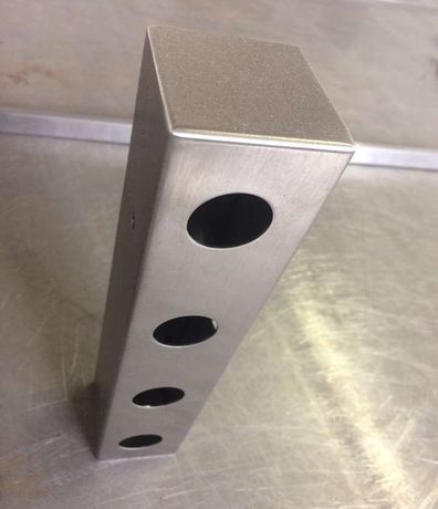 Su un tavolo è posata una scatola di acciaio inossidabile con dei buchi.