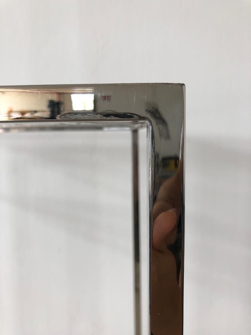 Una persona tiene in mano un contenitore di vetro con una cornice cromata.