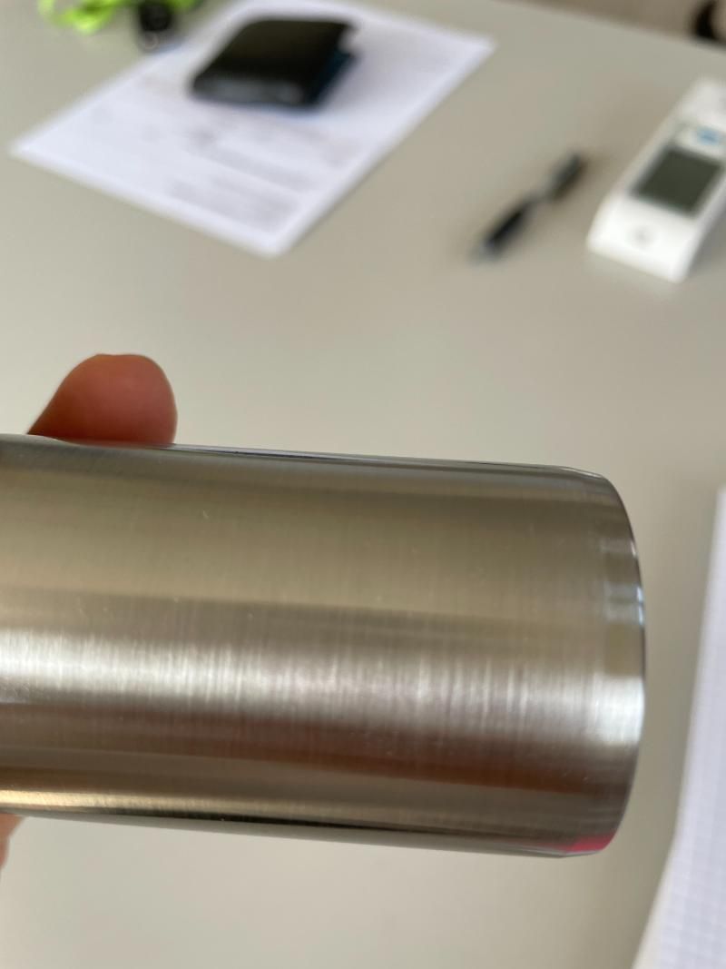 Una persona tiene in mano un tubo di acciaio inossidabile