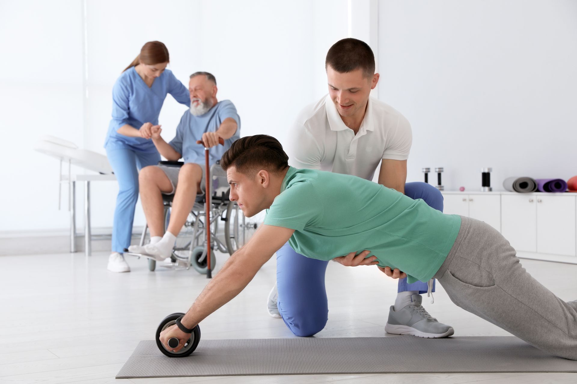 Two professional physiotherapists working with patients at a rehabilitation centre.