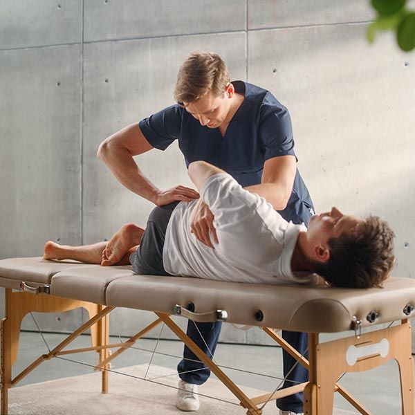 A physiotherapist works with a patient on specific muscle groups to recover from surgery. A physiotherapist works with a patient on specific muscle groups to recover from surgery.