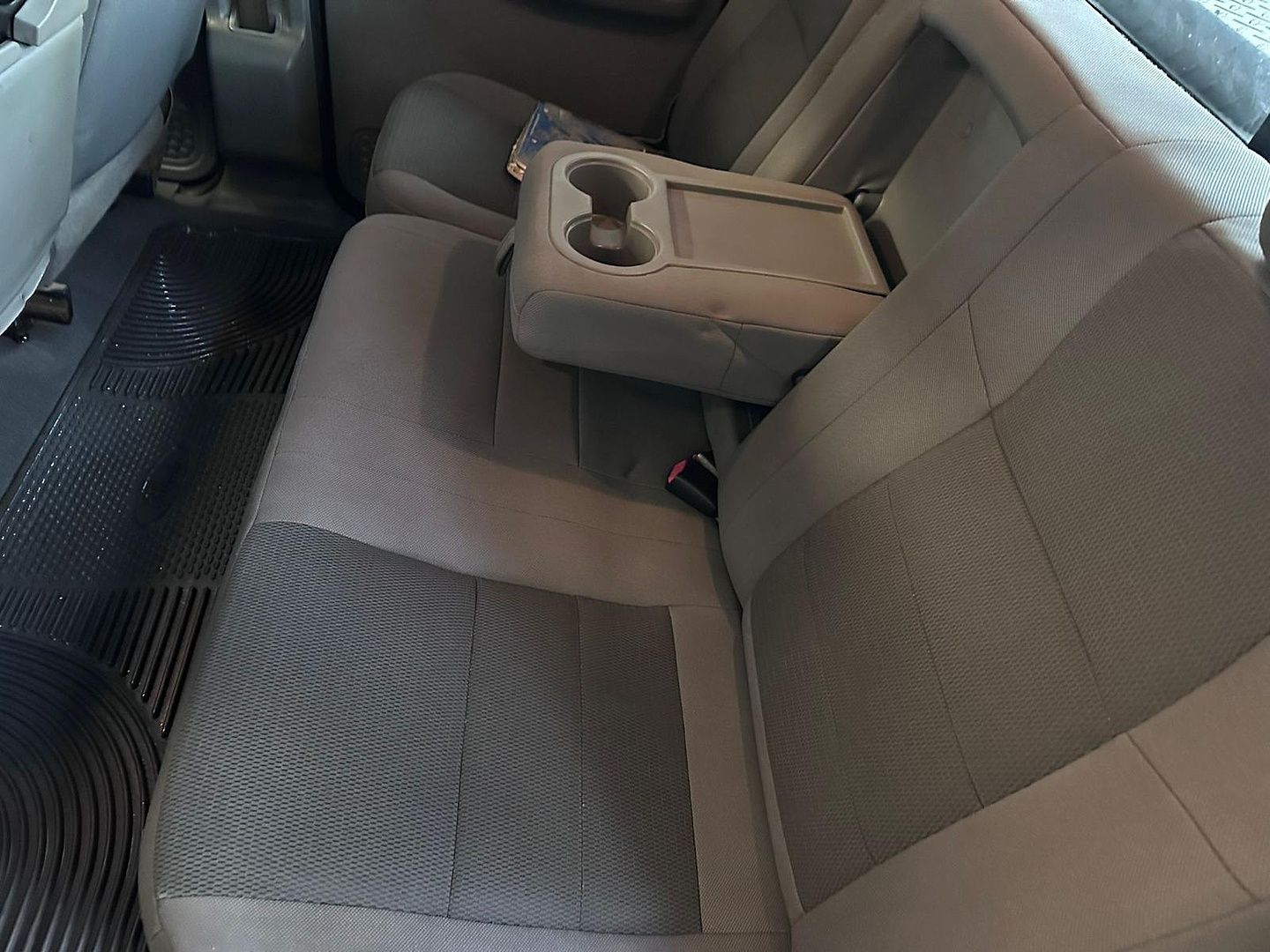 the back seat of a car with a cup holder on the arm rest .