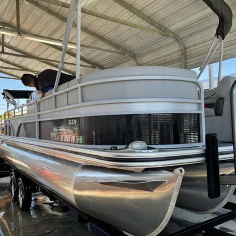 a pontoon boat is sitting on top of a trailer .