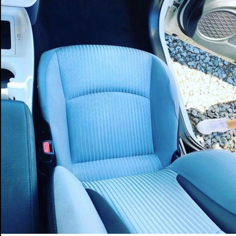 a blue car seat is being cleaned with a brush