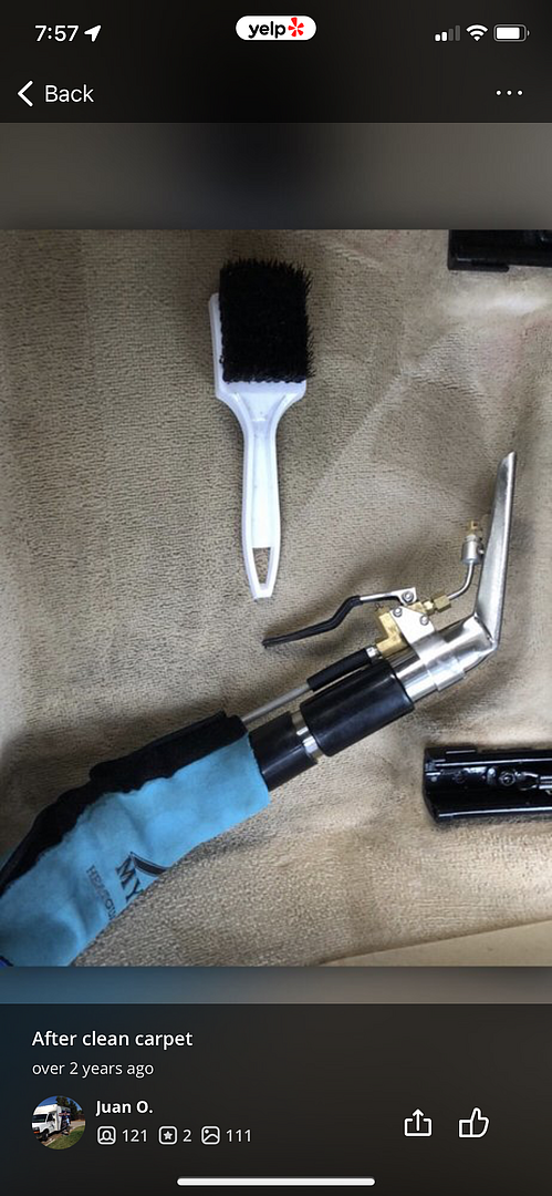 a vacuum cleaner is sitting on a carpet next to a brush .
