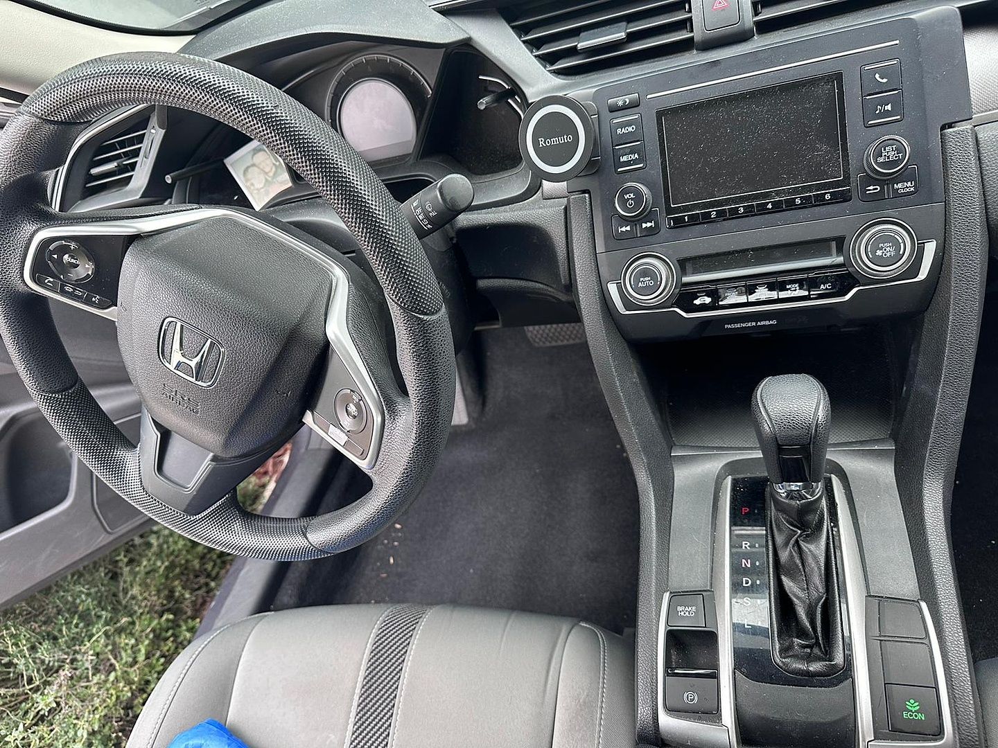 the interior of a honda civic with a steering wheel and dashboard .