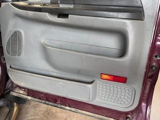 a close up of a purple car door with a red light on it .