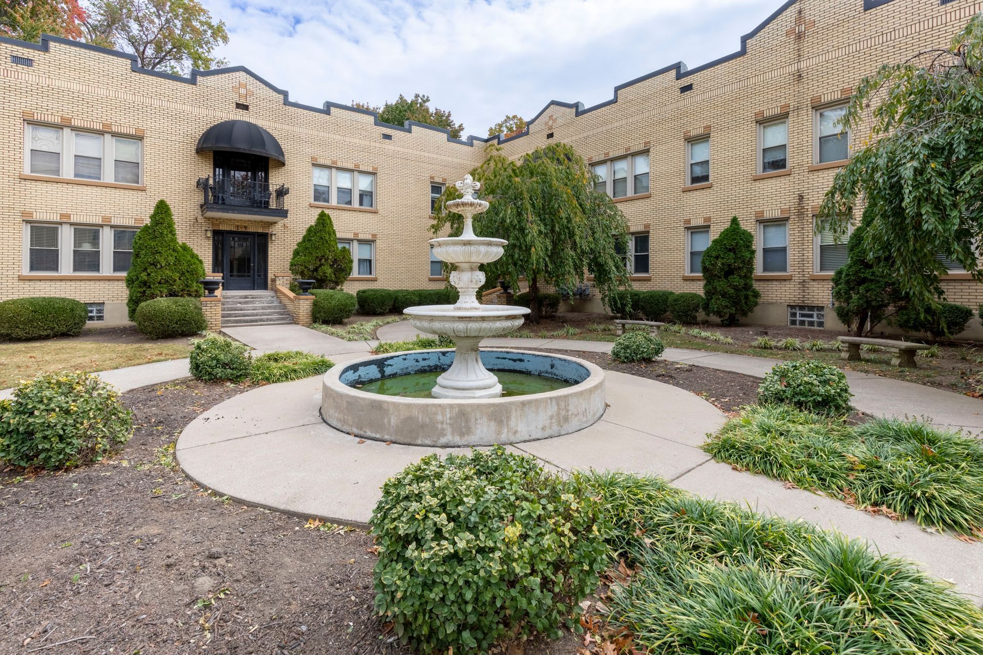 A large brick building with a fountain in front of it