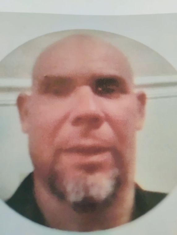 Close-up portrait of a bald man with a goatee against a plain light background