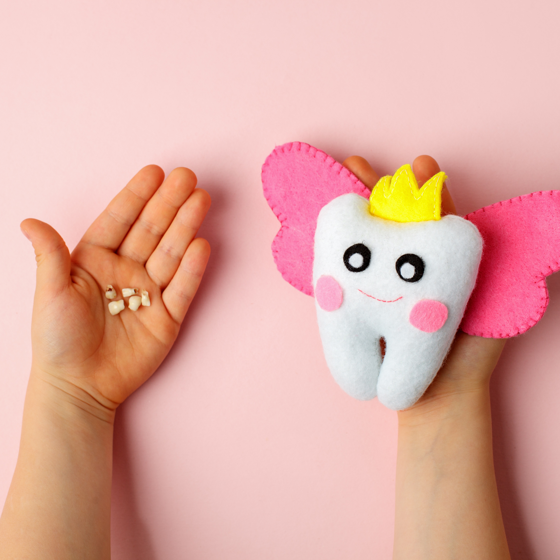 Child holding lost teeth and a tooth-shaped plush with wings and a crown on a pink background.