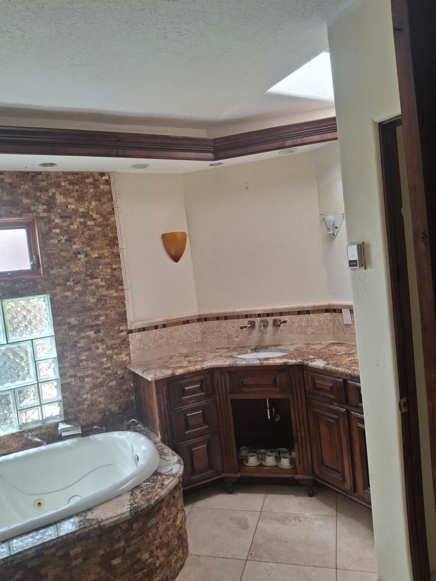 Bathroom with corner soaking tub, dark wood vanity, tiled walls, and tiled floor.