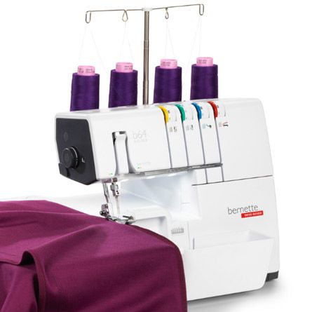 A white sewing machine is sitting on top of a purple cloth.