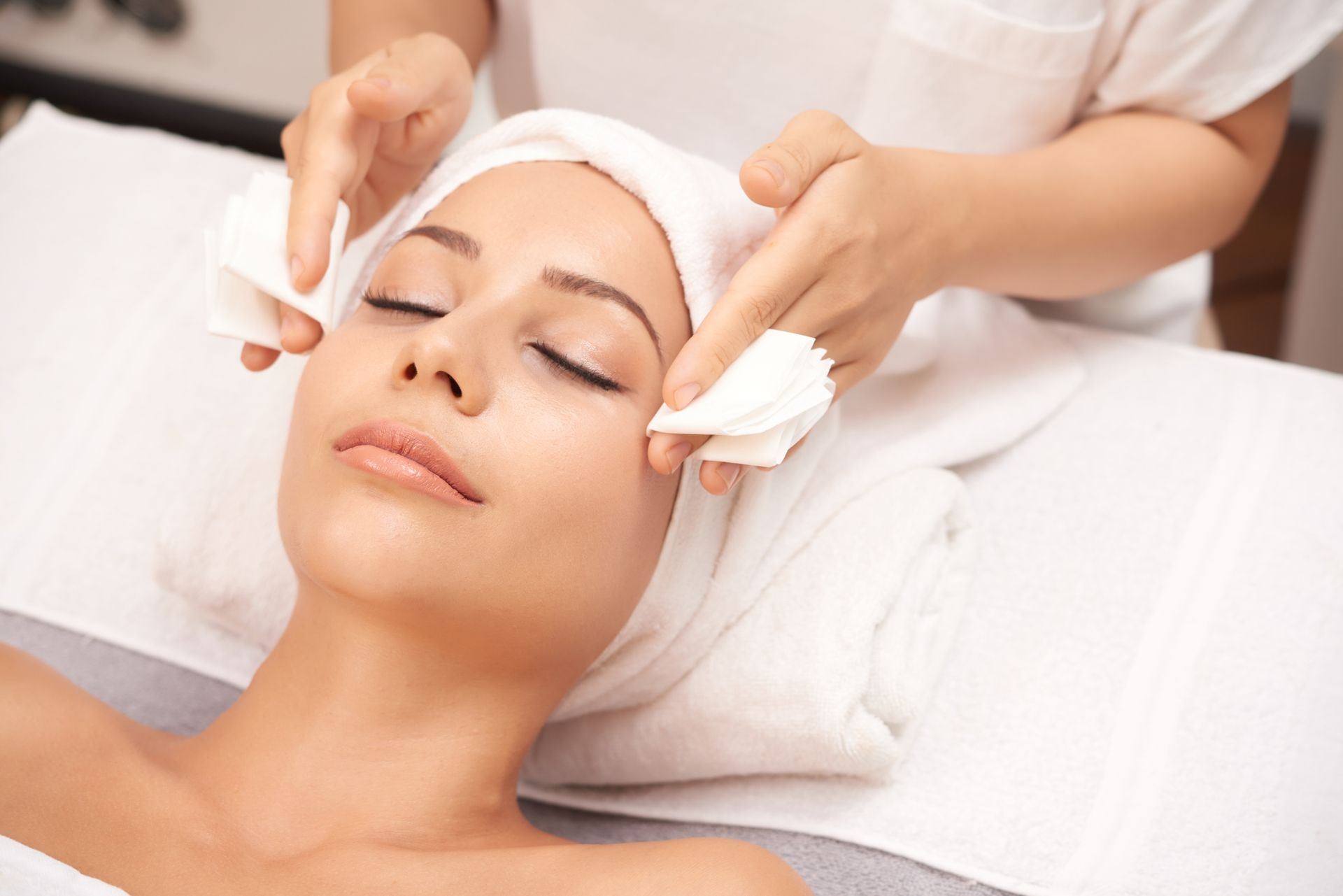 A woman is getting a facial treatment at a beauty salon.