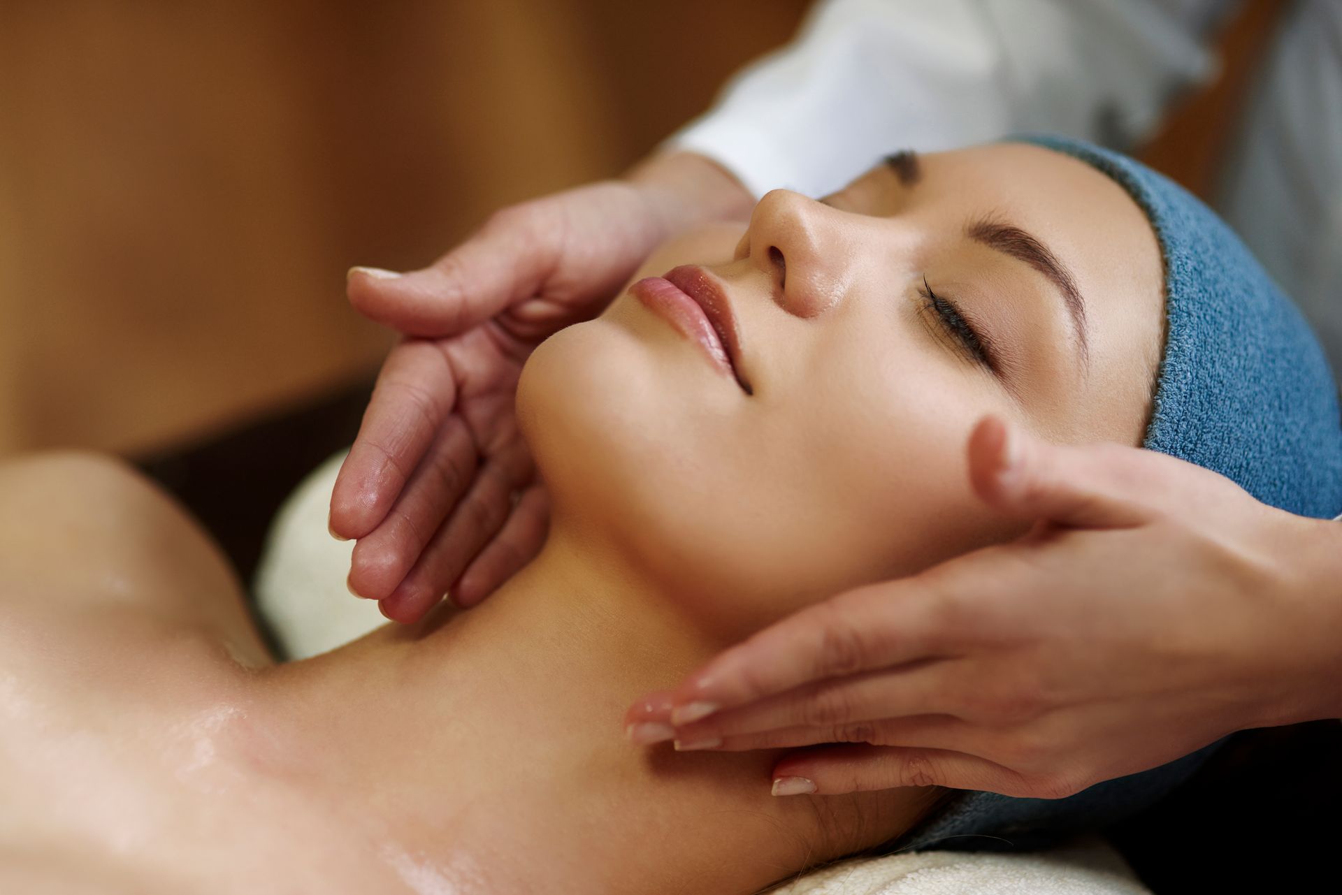 A woman is getting a facial massage at a spa.