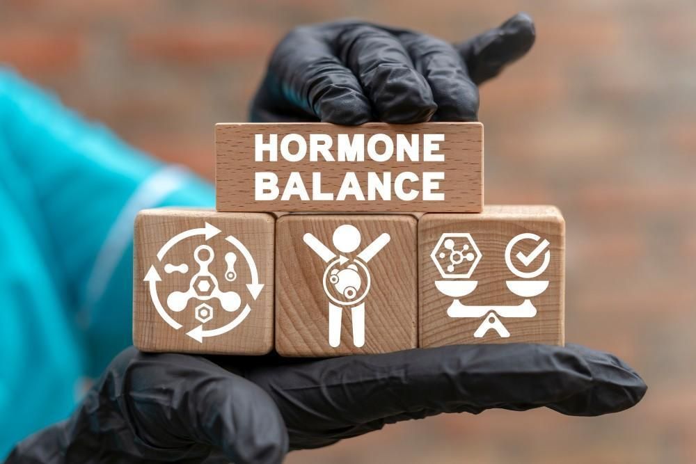 Person in black gloves holding wooden blocks spelling 