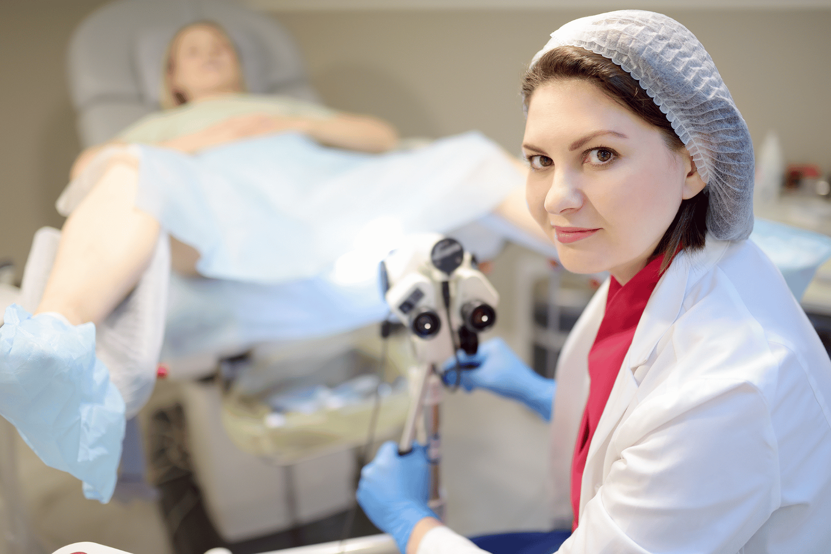 Doctor with a colposcope examining a patient during a gynecological exam.