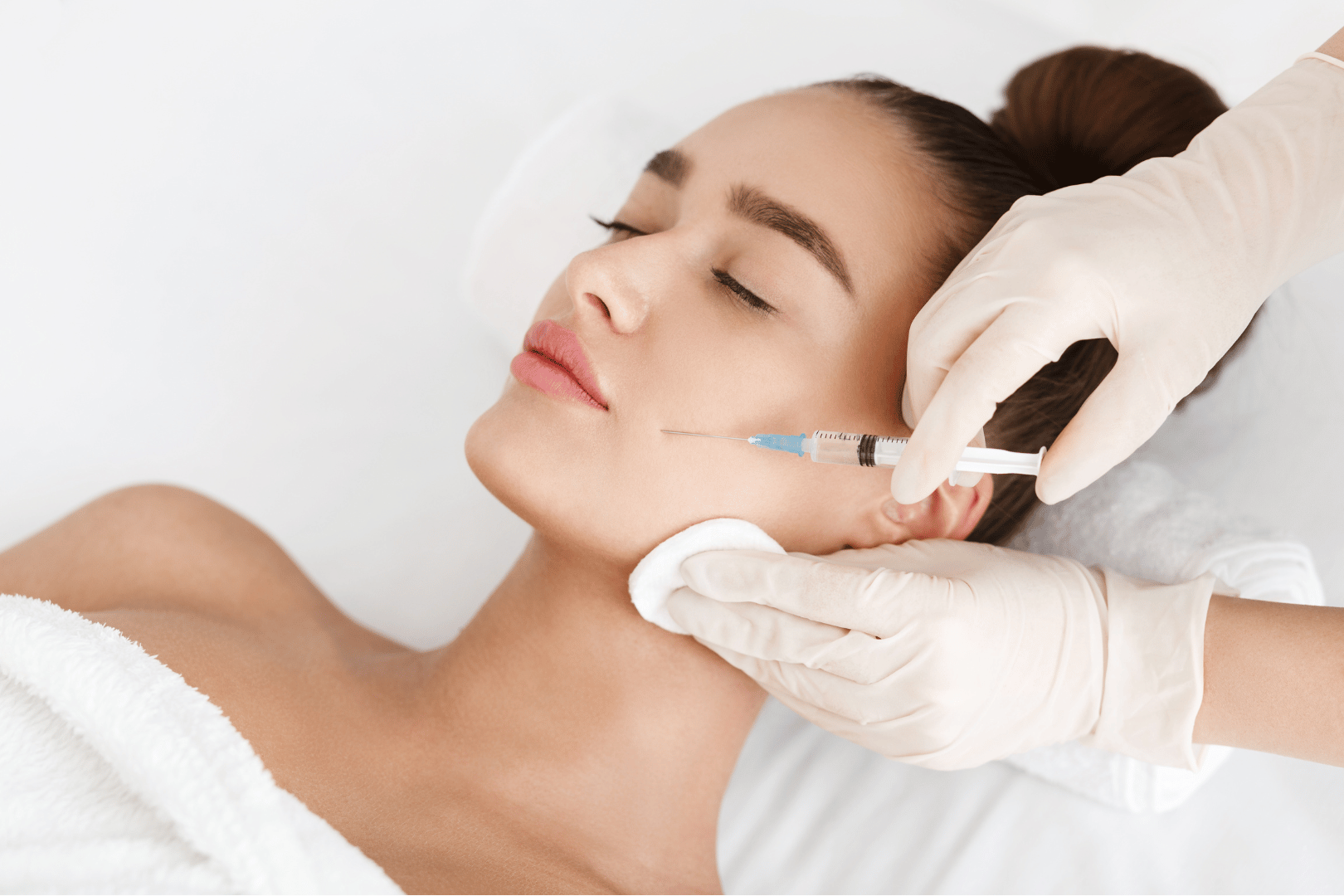 Woman receiving an injection in her cheek at a spa.