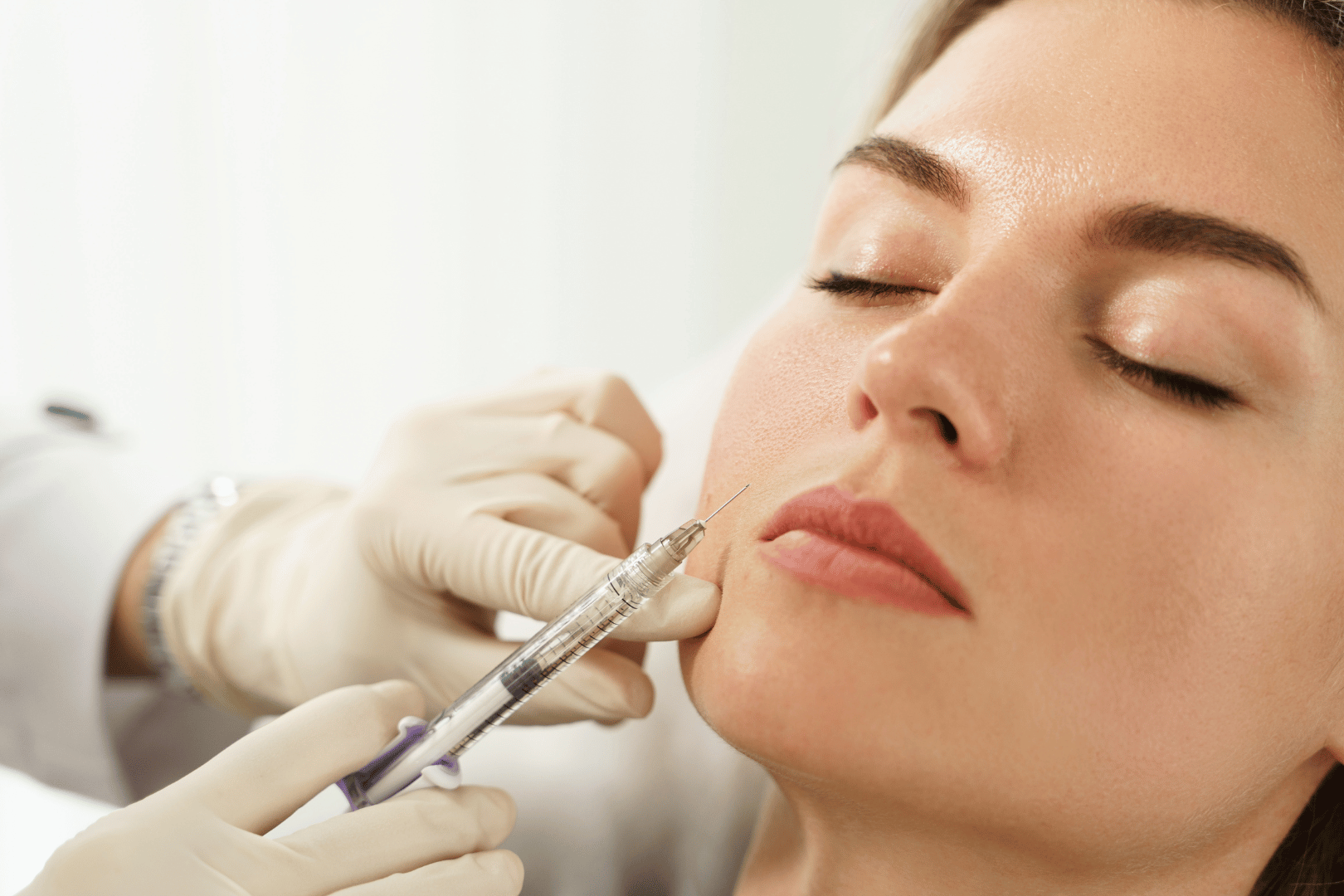Woman receiving facial treatment; close-up shows a device being used near her eye, wearing eye protection.