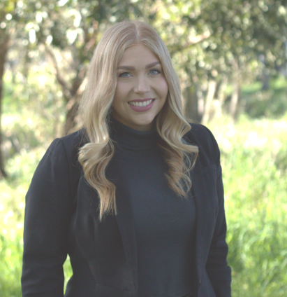 The woman is wearing a black jacket and smiling for the camera.