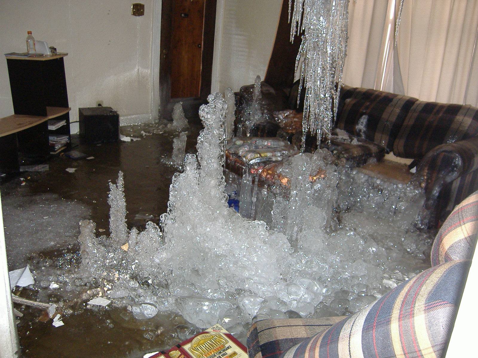 A living room with water coming out of the ceiling