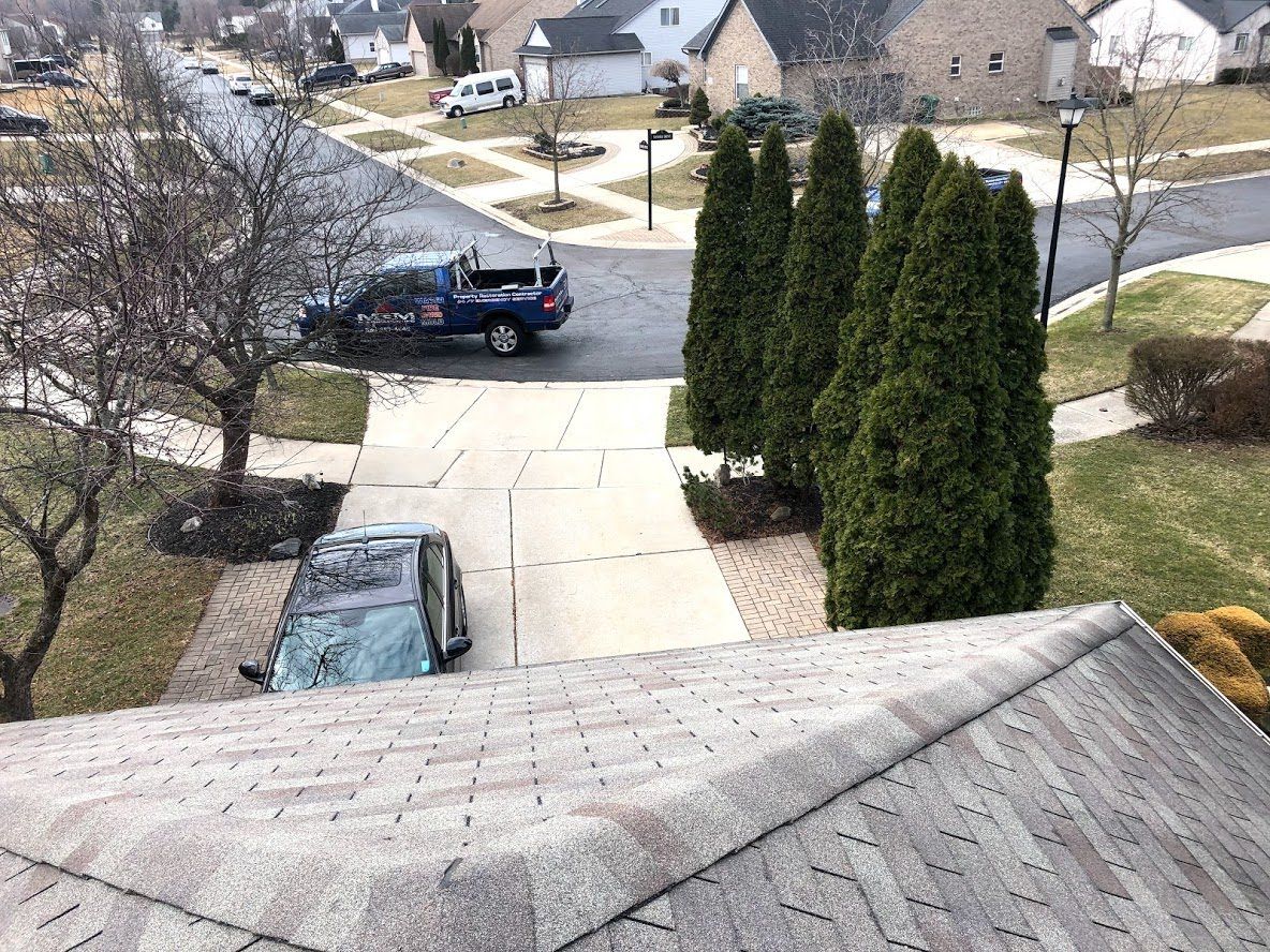 A blue truck is parked in front of a house in a residential neighborhood.