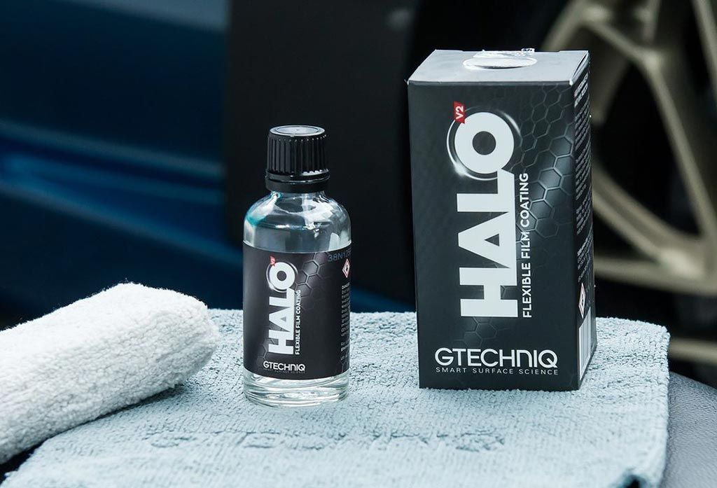 Small GTCHQ bottle beside black and white “MIV” box on a gray towel