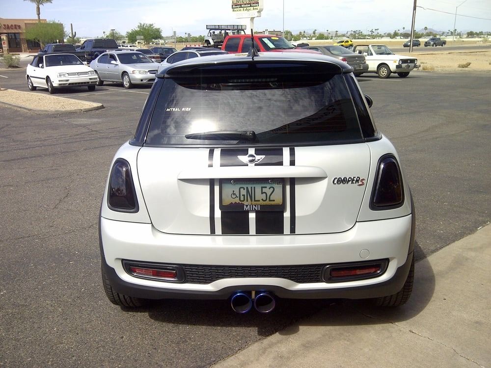 A white mini cooper with a license plate that says agn 52