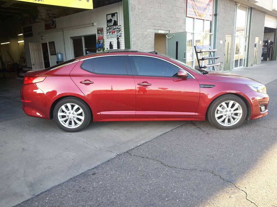 A red car is parked in front of a building.