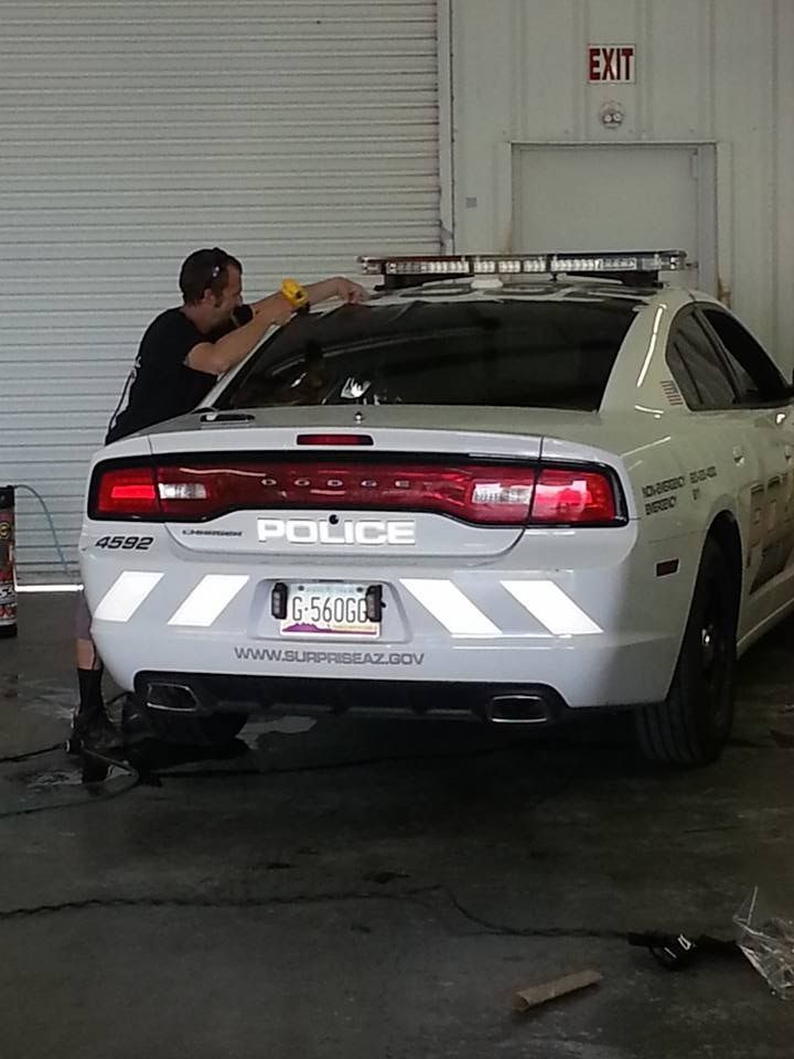 A man is working on a police car in a garage