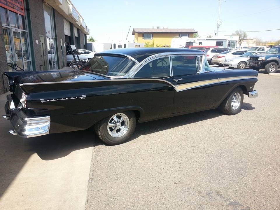 A black ford car is parked in a parking lot