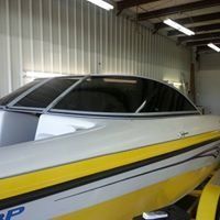 A white and yellow boat is parked in a garage.