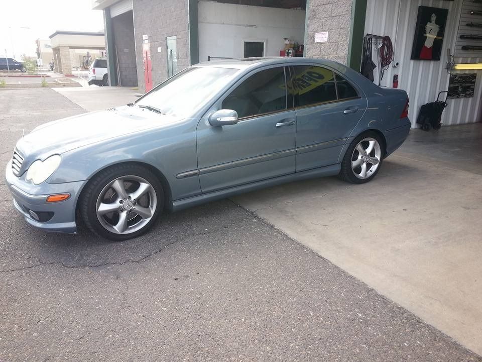 A blue car is parked in front of a garage