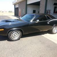 A black car is parked in front of a garage.