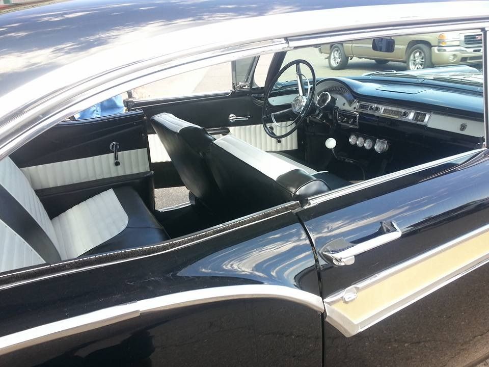 A black car with white seats and a steering wheel