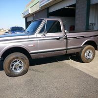 A silver truck is parked in front of a garage.