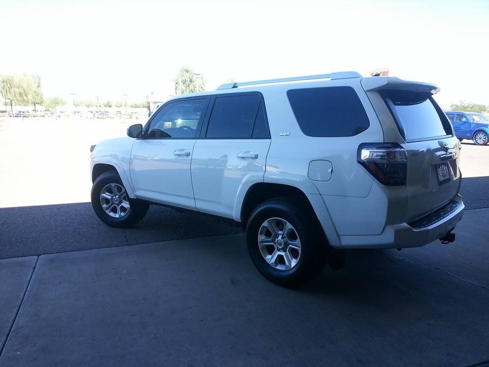 A white toyota 4runner is parked in a parking lot