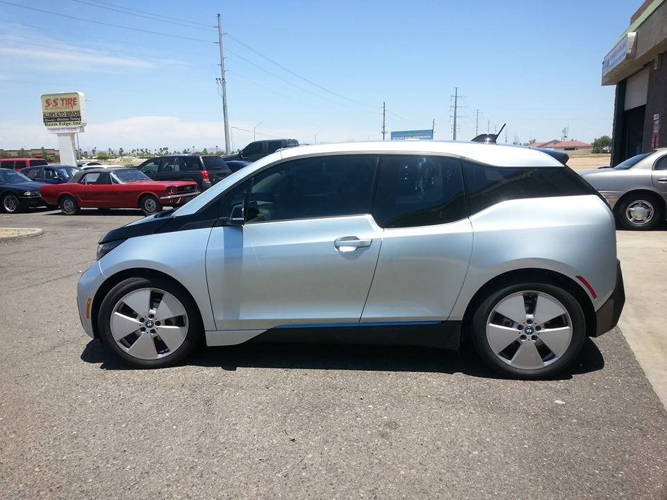 A silver bmw i3 is parked in a parking lot