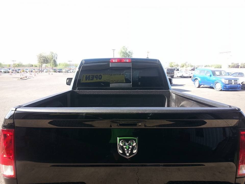 A black dodge truck is parked in a parking lot