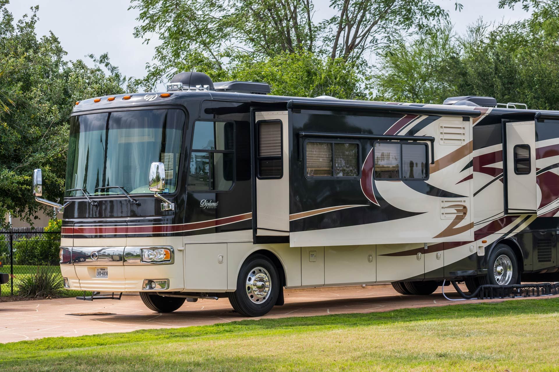 A large rv is parked in a grassy area.